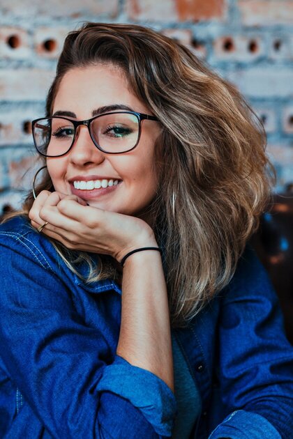 woman in glasses in a blue blouse smiling