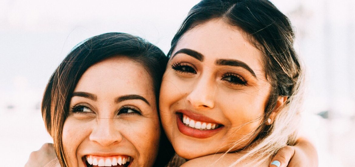 two girls smiling and embracing