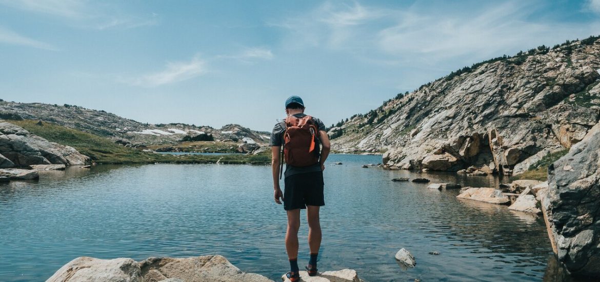 guy standing on rocks overlooking a small pond