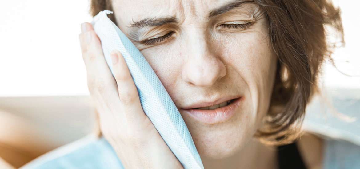 Woman holding a cold compress against her cheek to ease the pain of a toothache