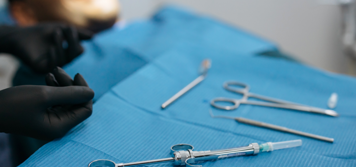 Young man waiting in dentist chair for procedure while dentist's hand uses dental tools